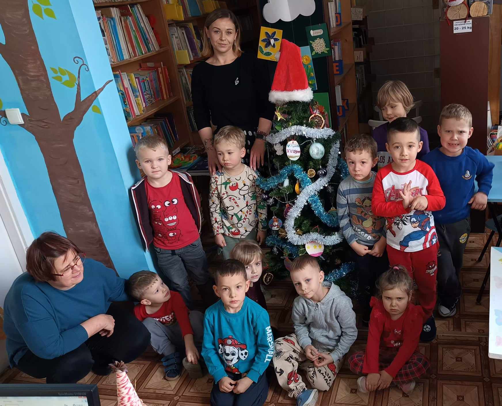 Przedszkolaki ubierają choinkę w bibliotece w Nowym Borku